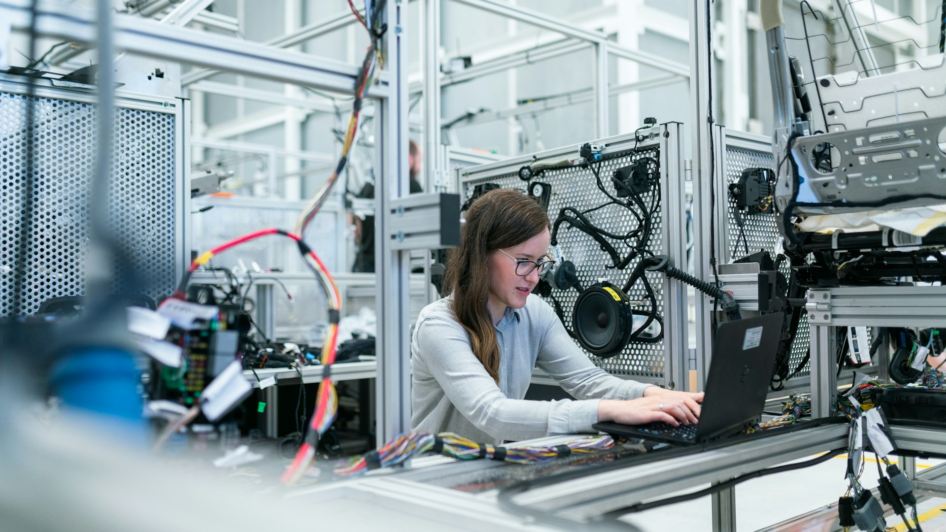 製造現場の技術者がノートPCでデータを確認する様子
